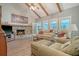 Inviting living room featuring a stone fireplace, vaulted ceilings with wooden beams, comfortable seating, and natural light at 125 Sumners Aly, Summerville, SC 29485