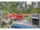Relaxing patio area featuring comfortable seating, grill, and a lush green backyard with wooded perimeter at 125 Sumners Aly, Summerville, SC 29485