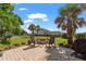 A brick patio features wood chairs, a fire pit, palm tree and green space at 129 Saluda Dr, Moncks Corner, SC 29461