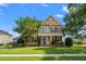 Beautiful two-story home with a well-manicured lawn, a porch, and mature trees at 129 Saluda Dr, Moncks Corner, SC 29461