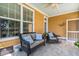 Covered porch features comfortable wicker furniture, blue pillows and outdoor views at 129 Saluda Dr, Moncks Corner, SC 29461