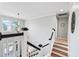 Bright staircase with wood steps, white railings, and a view of the front door at 129 Saluda Dr, Moncks Corner, SC 29461