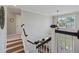 Elegant staircase with wood steps, white railings, and a view of the front door at 129 Saluda Dr, Moncks Corner, SC 29461