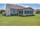 Inviting backyard featuring a sunroom, vibrant flowers, and lush green grass, perfect for outdoor relaxation and entertaining at 129 Schooner Bend Ave, Summerville, SC 29486