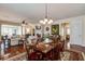 Open-concept dining room featuring a decorative chandelier, hardwood floors, and backyard views at 129 Schooner Bend Ave, Summerville, SC 29486