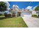 Charming one-story home showcasing manicured lawn, beautiful landscaping, and a two-car garage on a sunny day at 129 Schooner Bend Ave, Summerville, SC 29486