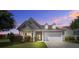 Charming one-story home showcasing manicured lawn, beautiful landscaping, and a two-car garage at twilight at 129 Schooner Bend Ave, Summerville, SC 29486