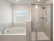 Bathtub and glass shower in a primary bathroom with tiled walls and floors at 1311 Berry Grove Dr, Summerville, SC 29485