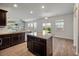 Kitchen with a granite counter island, wood cabinets, and a view into the living room at 1311 Berry Grove Dr, Summerville, SC 29485