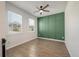 Cozy room featuring wood-look floors, a ceiling fan, green accent wall, and two windows at 1311 Berry Grove Dr, Summerville, SC 29485