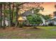 Back of house featuring a lush yard with mature trees offering shade, a covered porch, and tidy landscaping at 1311 Royal Links Dr, Mount Pleasant, SC 29466