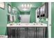 Green bathroom with a double sink vanity featuring cabinets, and a sliding glass door to the bath and shower combo at 1311 Royal Links Dr, Mount Pleasant, SC 29466