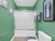 Bathroom with a shower over the tub combo with a sliding glass door, accented by light green walls and tiled flooring at 1311 Royal Links Dr, Mount Pleasant, SC 29466