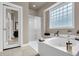 Bright bathroom featuring a walk-in shower and a soaking tub with tile flooring and frosted glass window at 1311 Royal Links Dr, Mount Pleasant, SC 29466