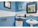 Charming powder room featuring bright blue walls, decorative artwork, and a pedestal sink at 1311 Royal Links Dr, Mount Pleasant, SC 29466