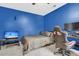 Gaming bedroom featuring blue walls, plush grey carpet, a flatscreen TV, and a gaming desk and chair at 1311 Royal Links Dr, Mount Pleasant, SC 29466