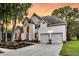 Two-story home with manicured lawn, beautiful flower beds, and a two-car garage with plenty of driveway space at 1311 Royal Links Dr, Mount Pleasant, SC 29466
