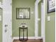 Hallway with hardwood floors and green walls, and an ornate mirror above a decorative table at 1311 Royal Links Dr, Mount Pleasant, SC 29466