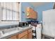Functional laundry room with sink, storage cabinets, washer, and dryer next to a bright window at 1311 Royal Links Dr, Mount Pleasant, SC 29466
