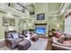 Spacious living room featuring tall windows, vaulted ceiling, and comfortable leather furniture at 1311 Royal Links Dr, Mount Pleasant, SC 29466