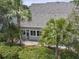 Back of home featuring screened-in porch, stone pavers, and a backdrop of lush landscaping and tall palm trees at 132 Fresh Meadow Ln, Mount Pleasant, SC 29466