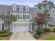 Inviting townhome with a two-car garage, dormer windows, and a beautifully landscaped yard at 132 Fresh Meadow Ln, Mount Pleasant, SC 29466