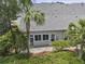 Home's rear exterior featuring lush landscaping and a screen porch at 132 Fresh Meadow Ln, Mount Pleasant, SC 29466