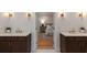 Dual vanities in a bathroom leading to a bedroom with hardwood floors and a neutral color palette at 14 55Th Ave, Isle of Palms, SC 29451