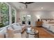 Bright bedroom featuring hardwood floors, a ceiling fan, and a sitting area with plush armchairs and large windows at 14 55Th Ave, Isle of Palms, SC 29451