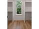 Walk-in closet featuring hardwood floors and a window with a view of lush greenery at 14 55Th Ave, Isle of Palms, SC 29451