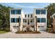 Charming two-story coastal home with blue shutters, dual garages, and inviting entrance at 14 55Th Ave, Isle of Palms, SC 29451