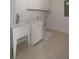 Well-lit laundry room featuring patterned tile floors, laundry sink, and white shaker cabinets at 14 55Th Ave, Isle of Palms, SC 29451