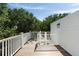 Wood deck with white railing, partial view of a white staircase, and leafy green trees in the background at 14 55Th Ave, Isle of Palms, SC 29451