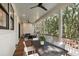 Covered porch with wood floors, ceiling fans, comfortable seating, and views of the wooded backyard at 14 55Th Ave, Isle of Palms, SC 29451