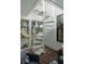 Bright sunroom featuring a white spiral staircase, wood floors, and outdoor views at 14 55Th Ave, Isle of Palms, SC 29451