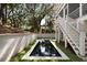 Rectangular in-ground swimming pool with grass surround and white stairs to the second story deck at 14 55Th Ave, Isle of Palms, SC 29451