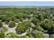 Wide aerial perspective captures a tranquil residential area with a scenic pond, surrounded by lush trees and charming homes at 1406 Oaklanding Rd, Mount Pleasant, SC 29464