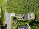 Aerial view showcases a home shaded by a mature tree, set within a well-maintained neighborhood and street at 1406 Oaklanding Rd, Mount Pleasant, SC 29464