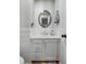 Cozy bathroom with white vanity, round mirror, and grey and white striped walls at 1406 Oaklanding Rd, Mount Pleasant, SC 29464
