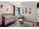 Bright Bedroom features a black crib, gray rocking chair, and soft lavender walls at 1406 Oaklanding Rd, Mount Pleasant, SC 29464