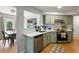Well-lit kitchen featuring stainless steel appliances, light green cabinets, and views into the dining room and living room at 1406 Oaklanding Rd, Mount Pleasant, SC 29464