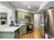 Functional kitchen features stainless steel appliances, light green cabinets, and hardwood floors, creating a cheerful culinary space at 1406 Oaklanding Rd, Mount Pleasant, SC 29464