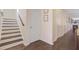 Image of a hallway with hardwood floors, staircase, white doors, and a view of the living room with fireplace at 142 Airy Dr, Summerville, SC 29486