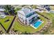 Stunning aerial view of a modern home with a metal roof, a private pool, a patio, and lush landscaping at 1491 Tomato Farm Cir, Mount Pleasant, SC 29464