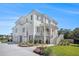 Beautiful two-story home with an attached three-car garage and a well-manicured lawn at 1491 Tomato Farm Cir, Mount Pleasant, SC 29464