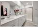 Bathroom featuring double sinks, sleek white cabinets, decorative mirror and glass enclosed shower at 160 Greenbelt Ct, Summerville, SC 29485