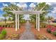Beautiful landscaping with a pergola and a view of a charming home in the distance at 160 Greenbelt Ct, Summerville, SC 29485