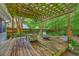 Outdoor patio area featuring an ornate pergola, stone fireplace, and lush green landscaping at 1972 Gray Battery Ct, Mount Pleasant, SC 29464