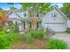 Charming two-story home featuring a bright red front door, mature landscaping, and an attached two car garage at 1972 Gray Battery Ct, Mount Pleasant, SC 29464