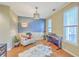 Stylish living room with hardwood floors, modern lighting, chair, piano and a serene blue accent wall at 1972 Gray Battery Ct, Mount Pleasant, SC 29464
